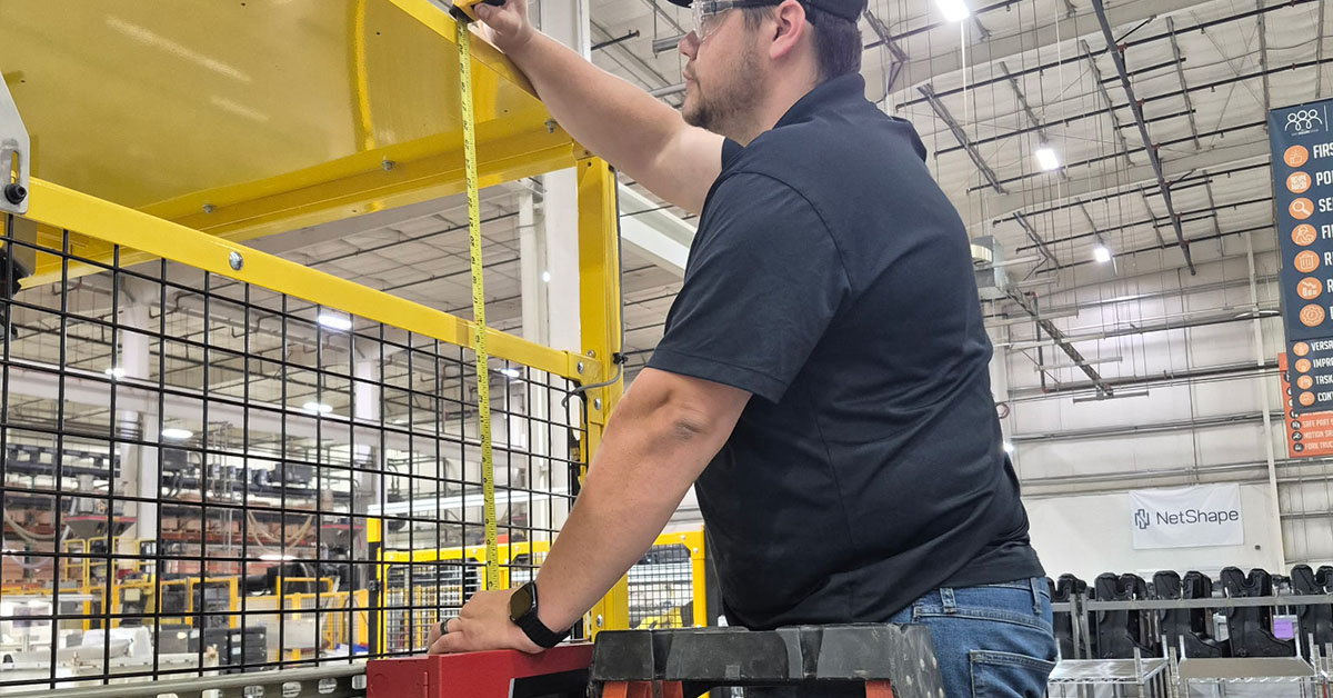 worker inspecting distance of the emergency fire box with a ruler